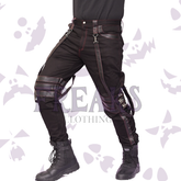 Black steampunk gothic pants with red stitching, leather straps, and metal buckles.