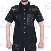 Black short-sleeve dapper darkness gothic shirt with leather shoulder straps, buckles, and chest pockets.