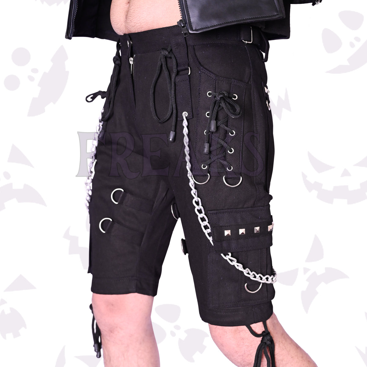 Black studded cargo shorts with silver chains, D-rings, and lace-up details on the thighs.